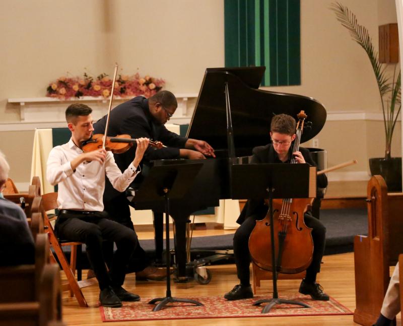 Chase Ward, Evan Hines, and Sophie Applbaum performing Claire Cowan’s 2008 piece called wood:strings:hammers:flesh at the concert